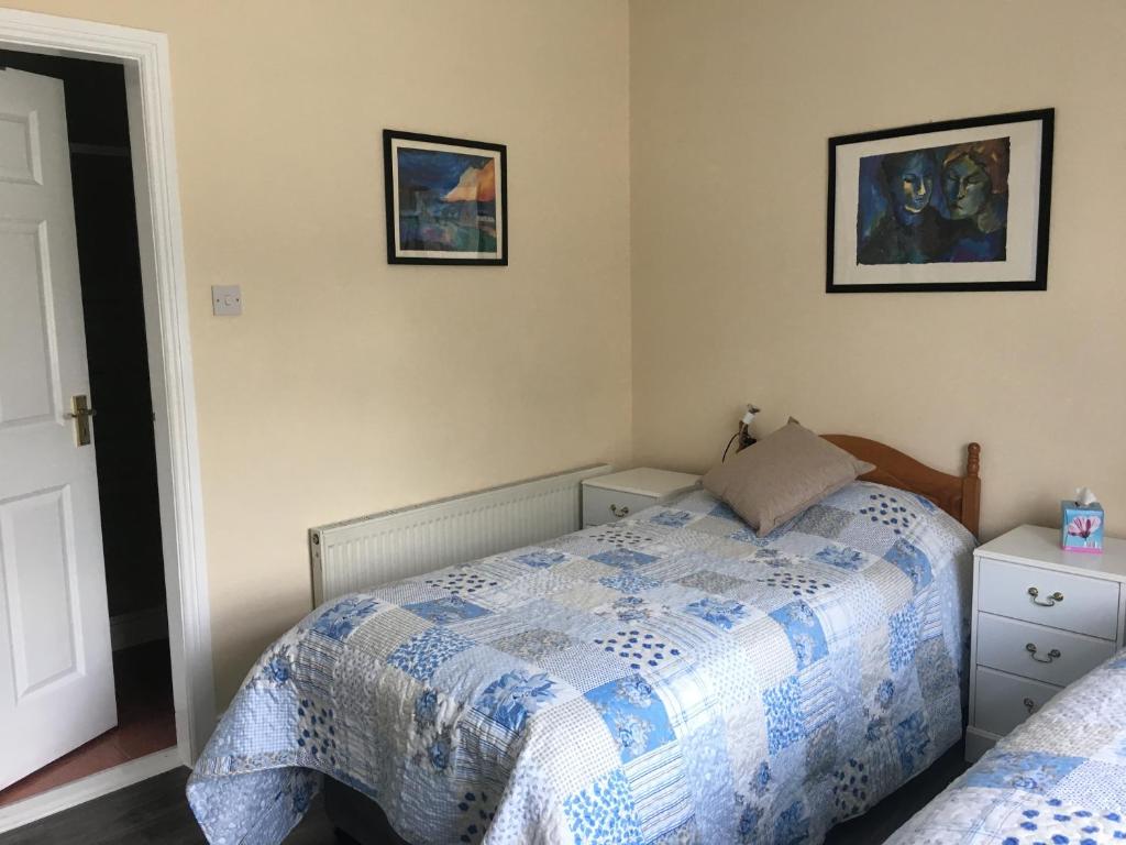 a bedroom with a bed and two pictures on the wall at Killurin Lodge in Wexford
