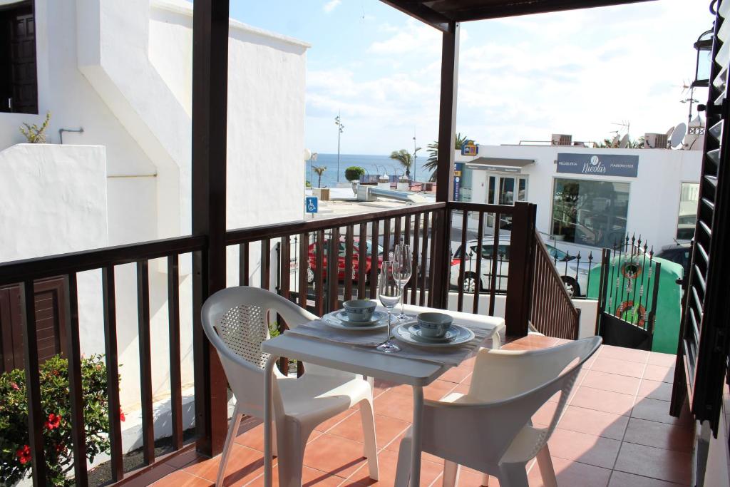 una mesa y sillas en un balcón con vistas al océano en Apartamento Steffi, en Tías
