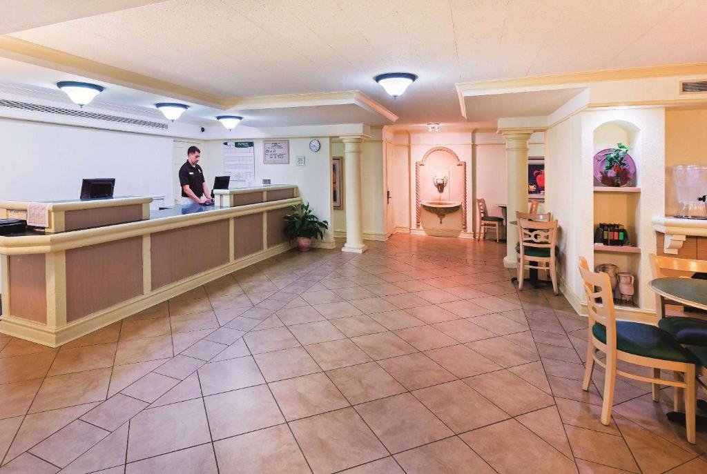 a man standing at a counter in a hospital lobby at La Quinta Inn by Wyndham College Station in College Station