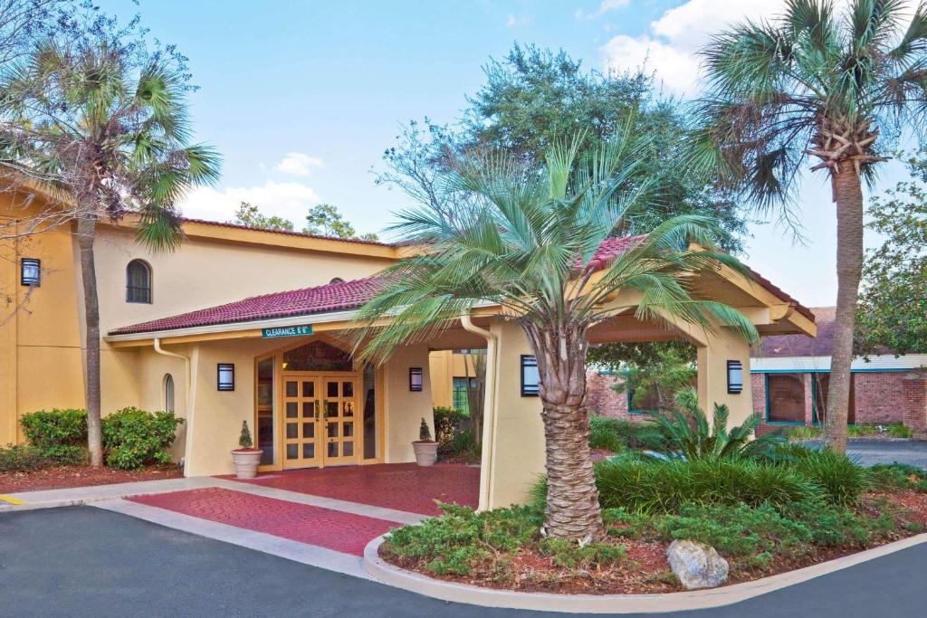 a hotel with palm trees in front of a building at La Quinta Inn by Wyndham Tallahassee North in Tallahassee