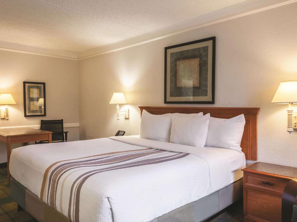 ein Hotelzimmer mit einem großen Bett und einem Schreibtisch in der Unterkunft La Quinta Inn by Wyndham New Orleans West Bank / Gretna in Gretna