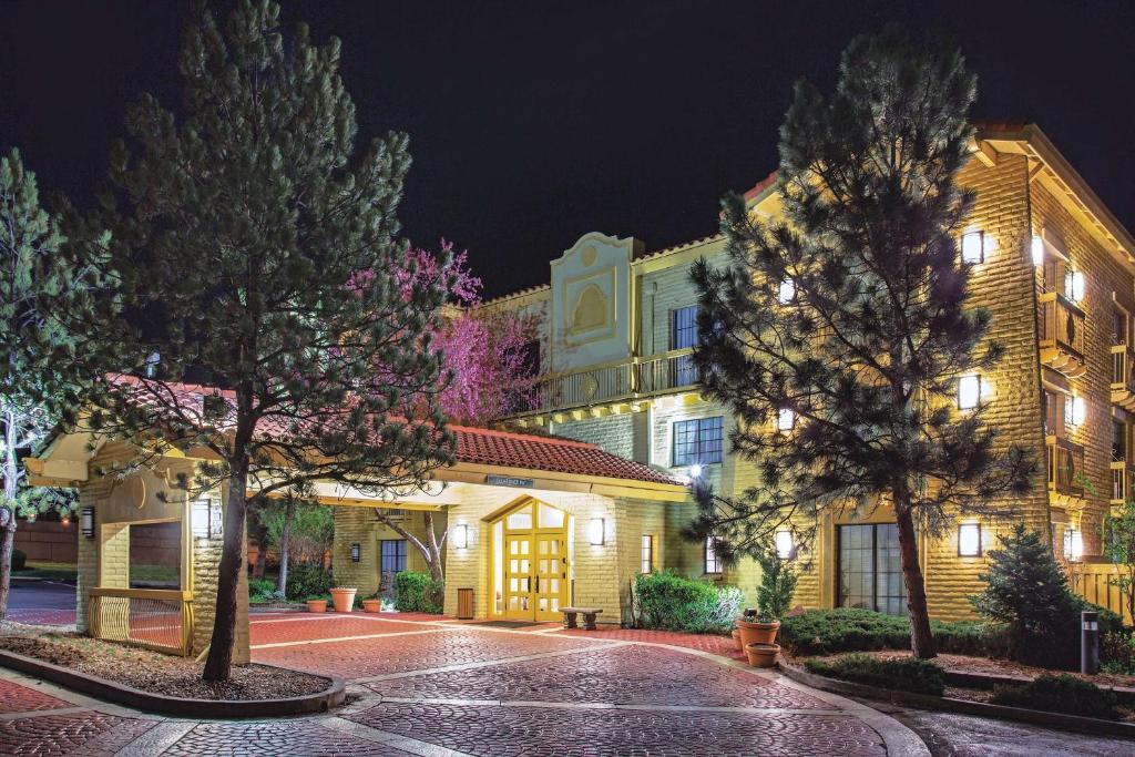 a building with trees in front of it at night at La Quinta Inn by Wyndham Denver Westminster in Westminster