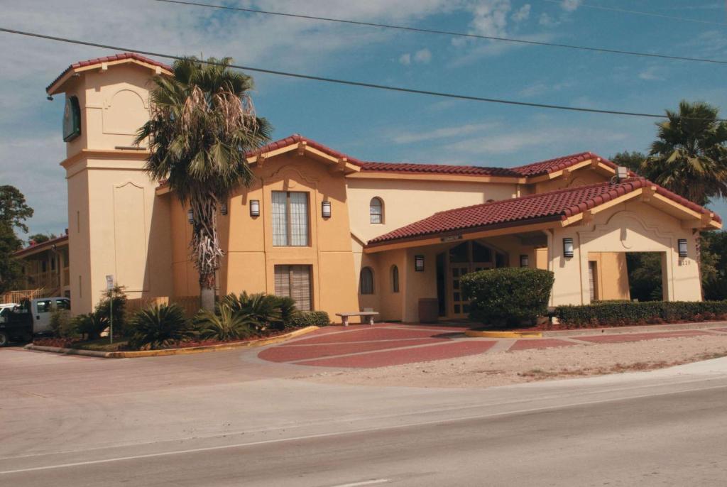 a building with a palm tree in front of a street at La Quinta Inn by Wyndham Lufkin in Lufkin