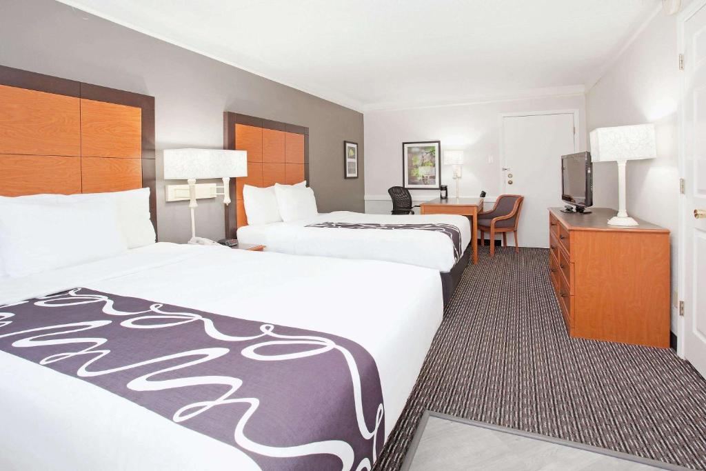 a hotel room with two beds and a desk at La Quinta Inn by Wyndham Denver Golden in Golden