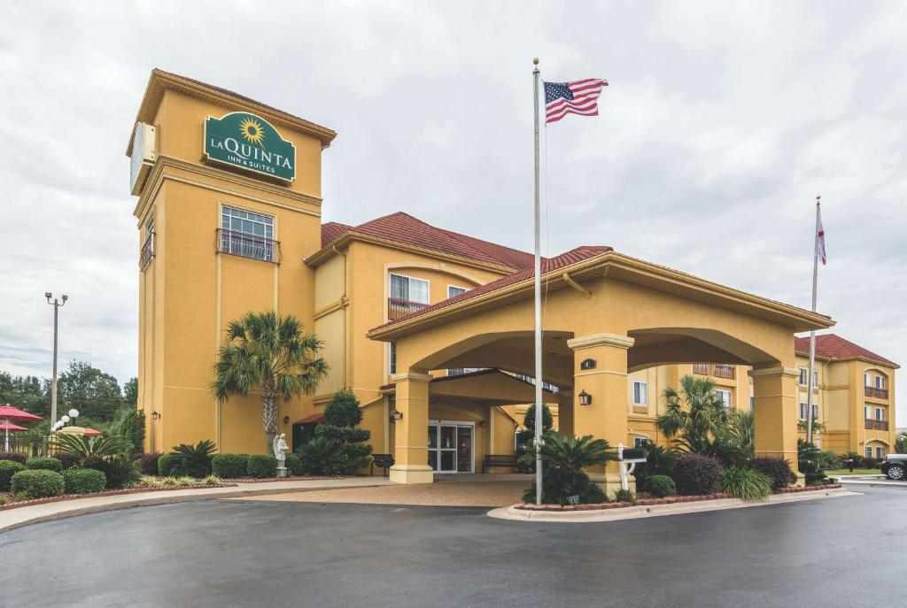 un hôtel arborant un drapeau américain devant lui dans l'établissement La Quinta by Wyndham Prattville, à Prattville