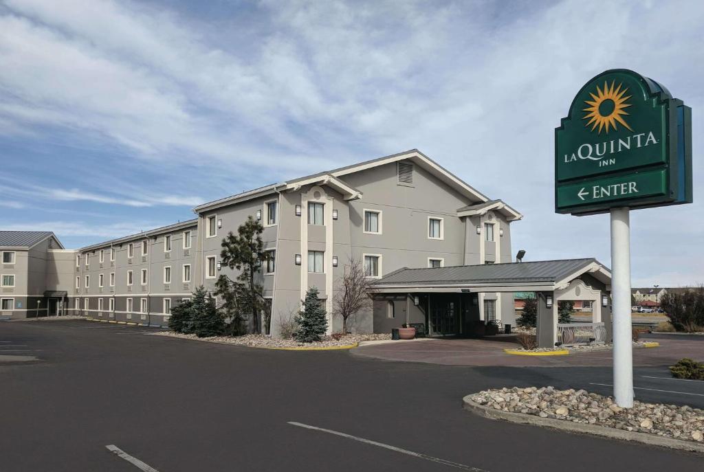 un hôtel avec un panneau devant un bâtiment dans l'établissement La Quinta Inn by Wyndham Cheyenne, à Cheyenne