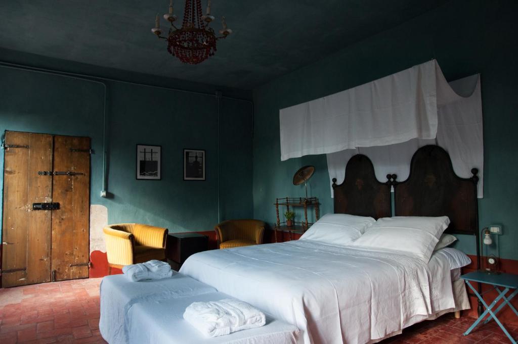 a bedroom with a large white bed and green walls at Corte Mantovanella in SantʼAntonio