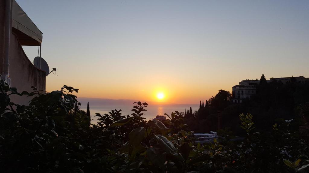 einen Sonnenuntergang über dem Meer von einem Gebäude in der Unterkunft Il Rosmarino Apartment in Taormina