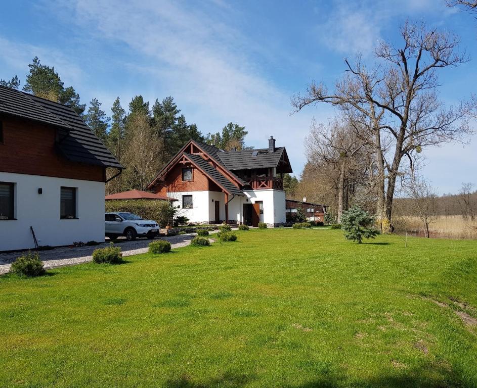 Bartoszylas的住宿－Gościniec Kaszubski Las, Ruda 3，前面有绿色草坪的房子