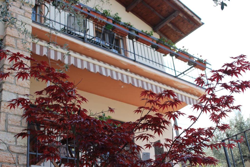 un edificio con balcone con foglie rosse di Casa Ines Fronte Lago a Brenzone sul Garda