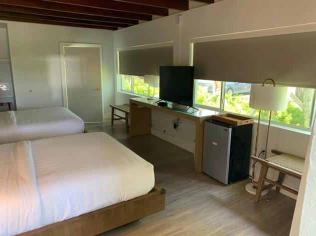 Sunset Inn في إسلامورادا: غرفة نوم مع سرير ومكتب مع مصباح