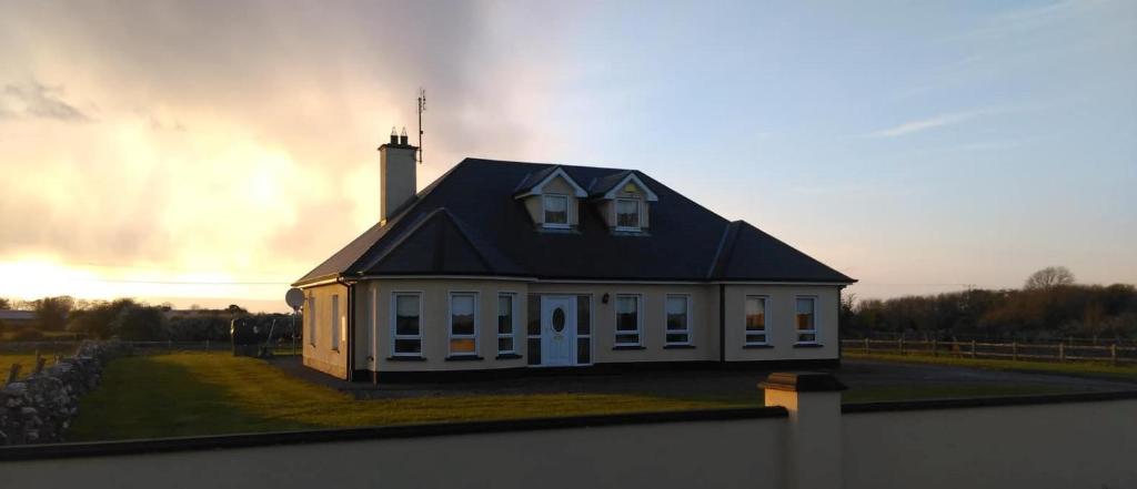 a small white house with a black roof at Warm and welcoming family home in Ballinrobe