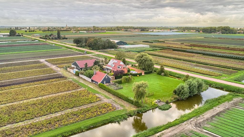 an aerial view of a farm with a house and a river at B&B “Te Warskip bij BlokVis” in Medemblik