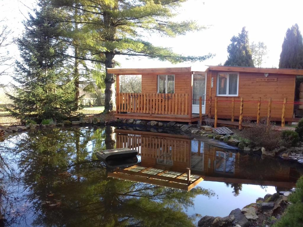 eine Hütte auf einem Teich mit einem Haus in der Unterkunft gite de beletou in Jourgnac