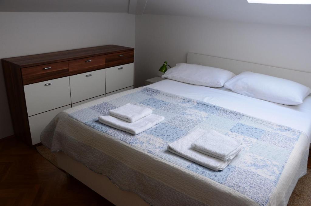 1 dormitorio con 1 cama con 2 toallas en Apartment Tanja, en Cres