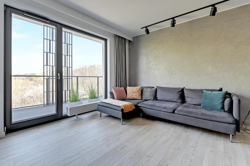 格地尼亞的住宿－The Scandic Suite Sopot-Gdynia Apartment，带沙发和大窗户的客厅