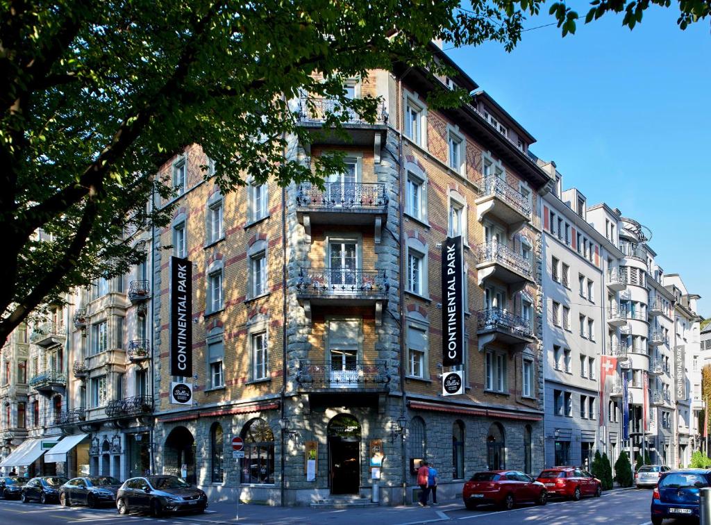 un edificio en una calle con coches aparcados delante en Continental Park, en Lucerna