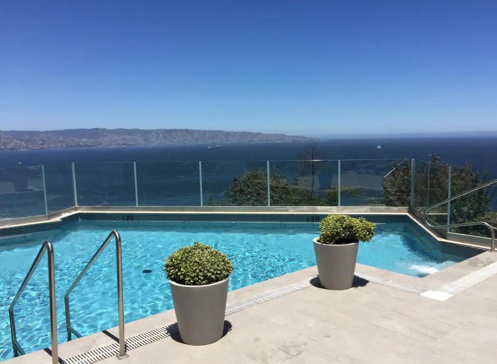 a swimming pool with a view of the ocean at Apartamento Piso 19 Reñaca Vista al Mar in Viña del Mar