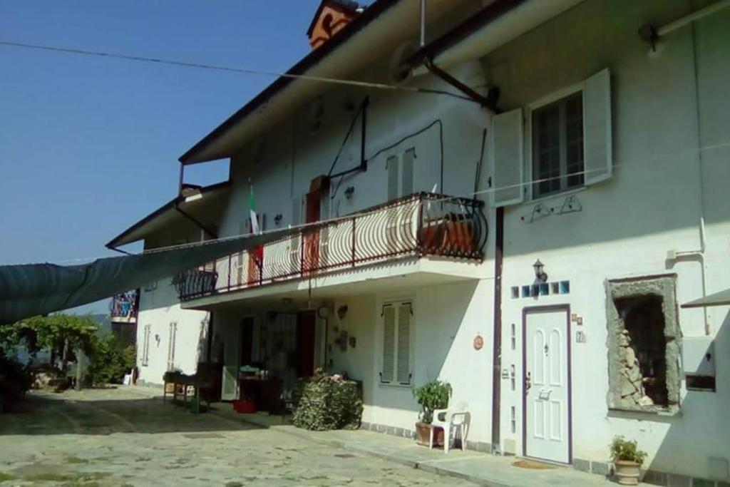 Biały budynek z balkonem na boku w obiekcie suite in cascina affittacamere w mieście Casalborgone