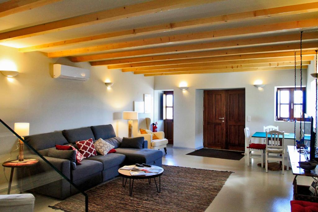 a living room with a blue couch and a table at Casa do Cais da Torreira in Torreira