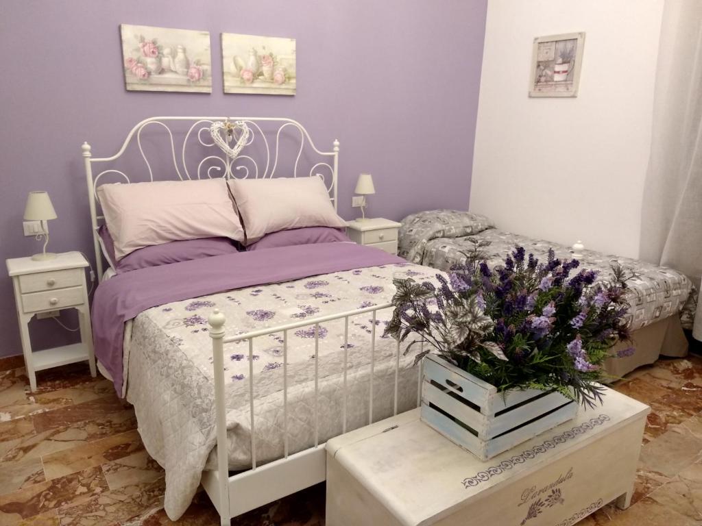 um quarto com uma cama e flores sobre uma mesa em Tra Monti e Mare em La Spezia