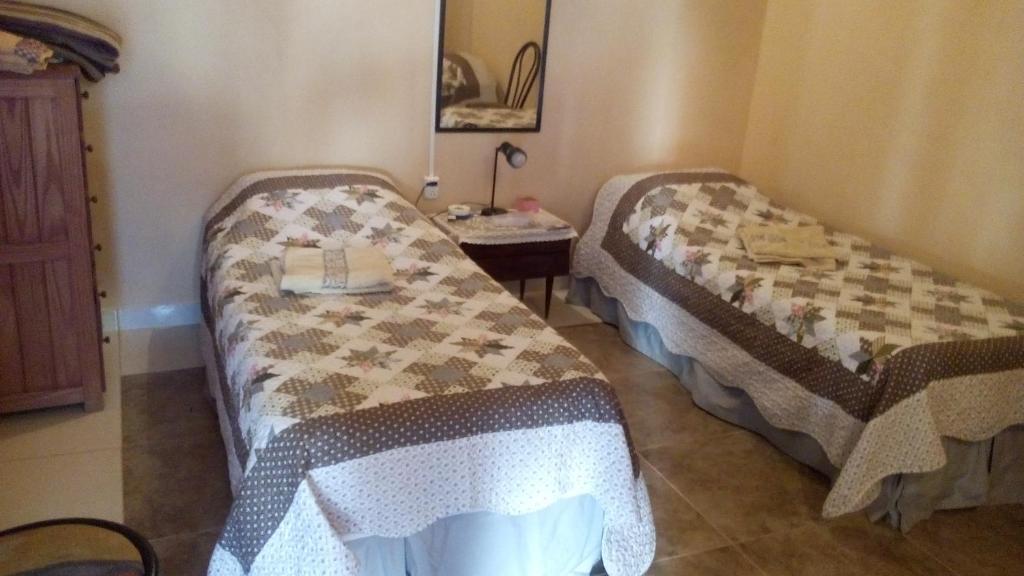 Cette chambre comprend 2 lits et une table. dans l'établissement El patio de marta, à Posadas