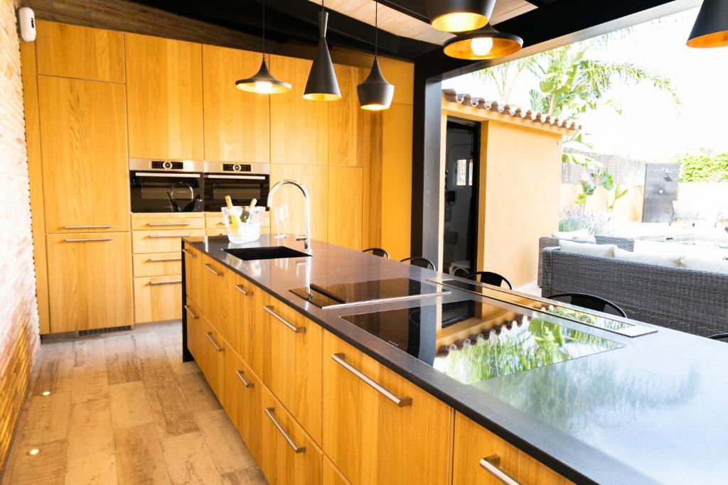 a kitchen with wooden cabinets and a black counter top at Villa Bo in Deltebre