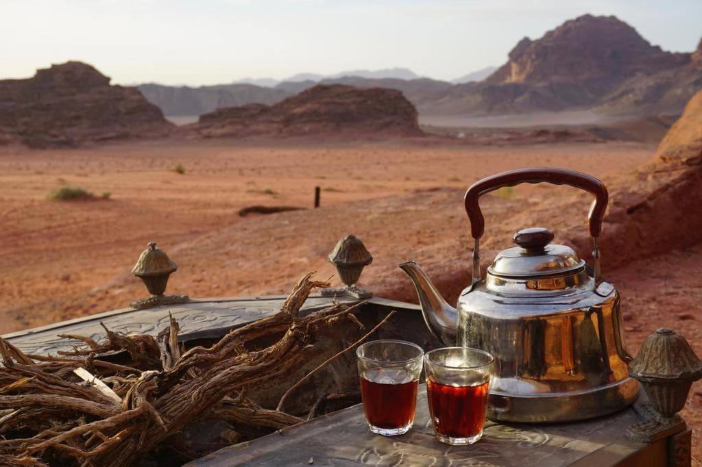 瓦迪拉姆的住宿－Rise Camp Wadi Rum，茶壶和沙漠桌子上的两杯