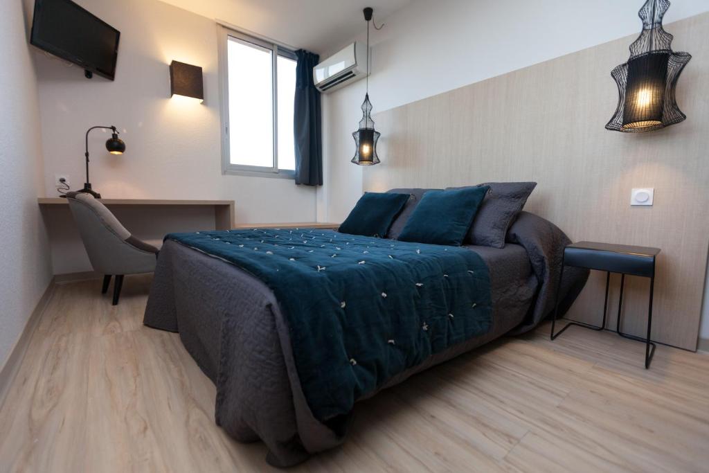 a bedroom with a large bed with blue pillows at La Quietat in Toulouse