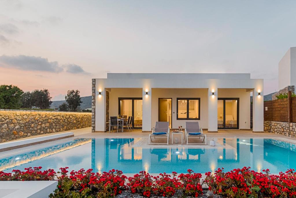 a villa with a swimming pool and two chairs at Prasonisi Villas in Kattavía