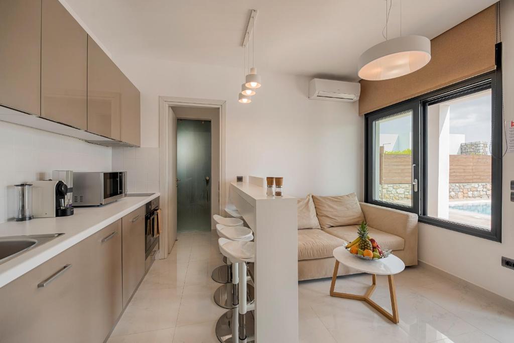 a kitchen and living room with a couch and a table at Prasonisi Villas in Kattavía