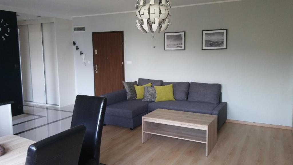 a living room with a blue couch and a table at U Hanusi in Ostróda