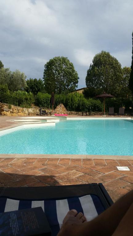 a person laying on a bench in front of a swimming pool at Appartamento Camelia a Castelfalfi in Montaione