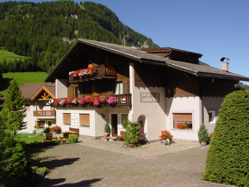 un gran edificio con flores en el balcón en Garnì Conturina, en Santa Cristina Valgardena