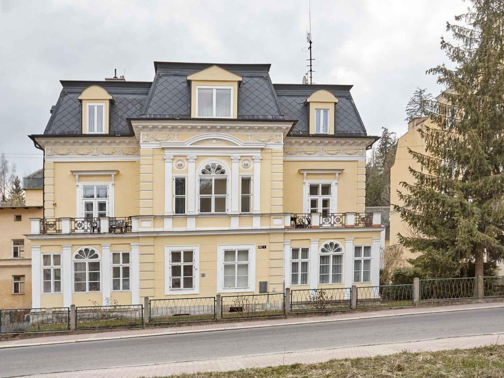 una gran casa amarilla con techo negro en Apartament Olga, en Mariánské Lázně