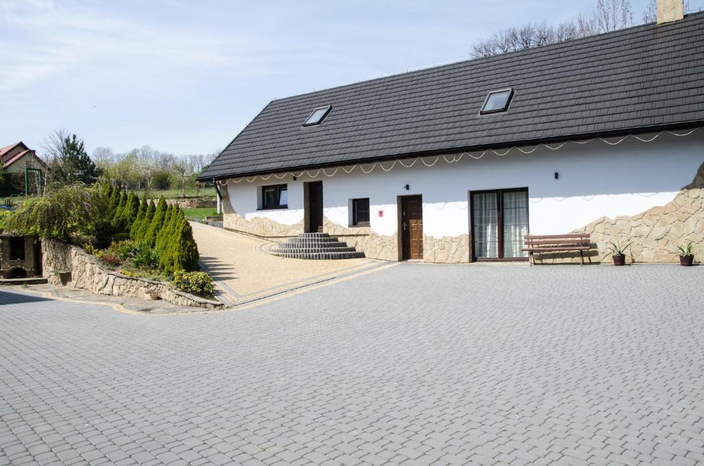 a white house with a brick driveway at Pod Dębami in Wadowice