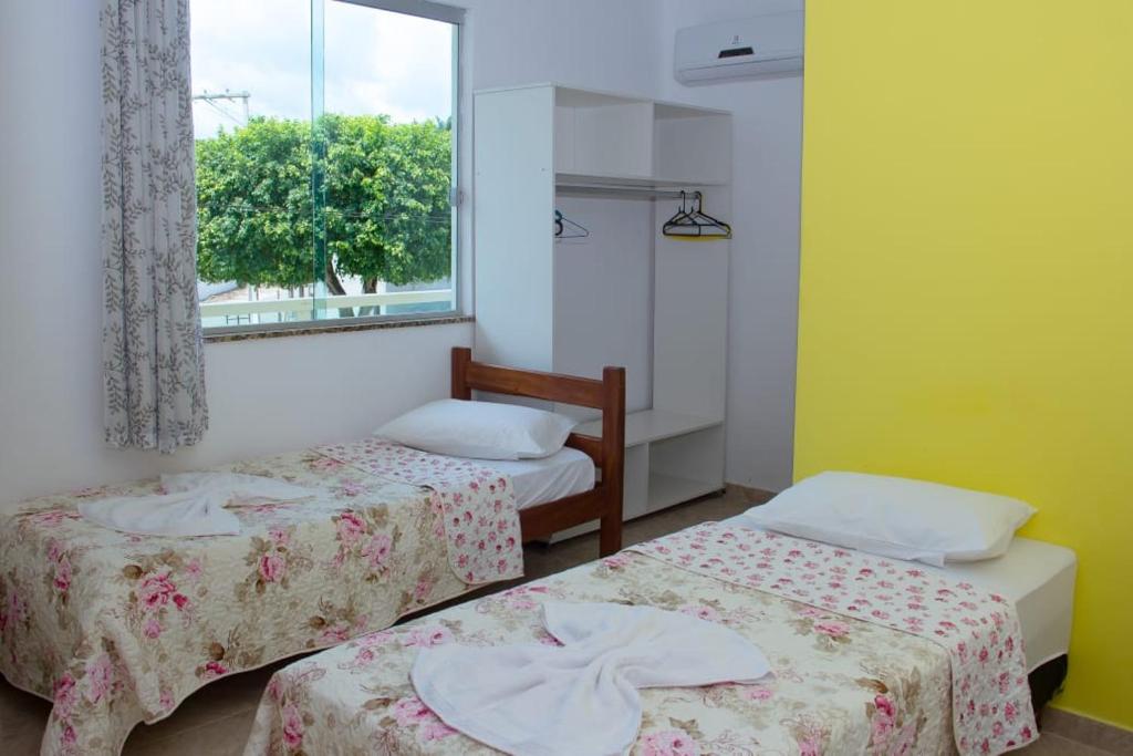 Zimmer mit 2 Betten und einem Fenster in der Unterkunft POUSADA DA ILHA in Una