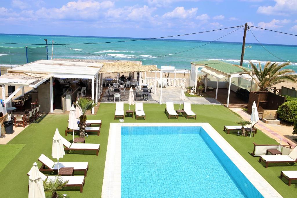 un resort con piscina, sedie e oceano di Havana 1 Sea and Pool Apartment ad Amoudara Herakliou
