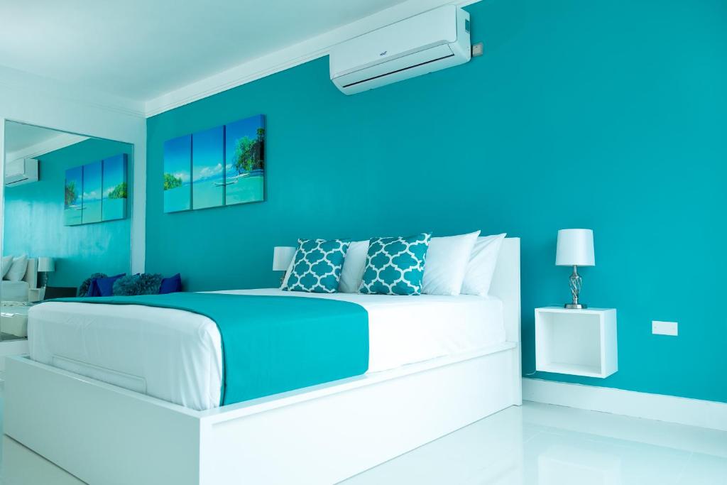 a blue bedroom with a large bed with blue walls at Elegance at 20 South in Kingston