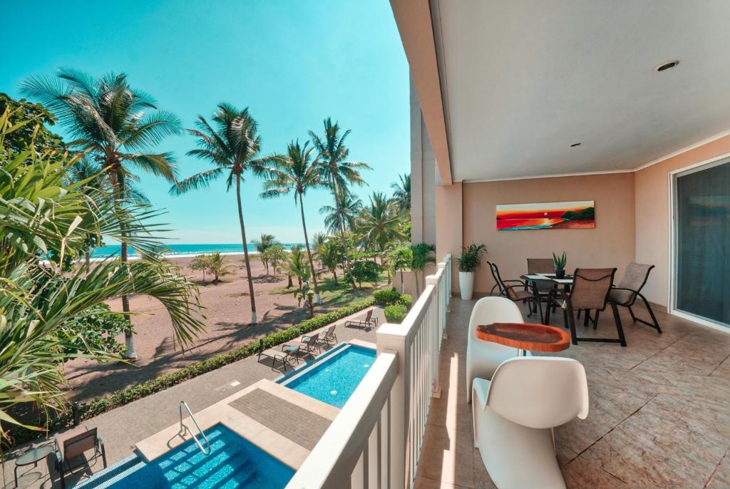 einen Balkon mit Blick auf den Strand und das Meer in der Unterkunft The Palms Ocean Club Resort in Jacó