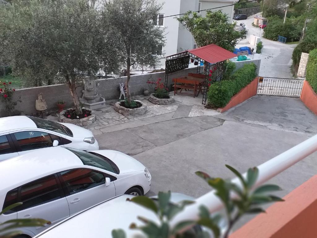 twee witte auto's geparkeerd op een parkeerplaats met een tafel bij Apartment Matkovic in Tivat