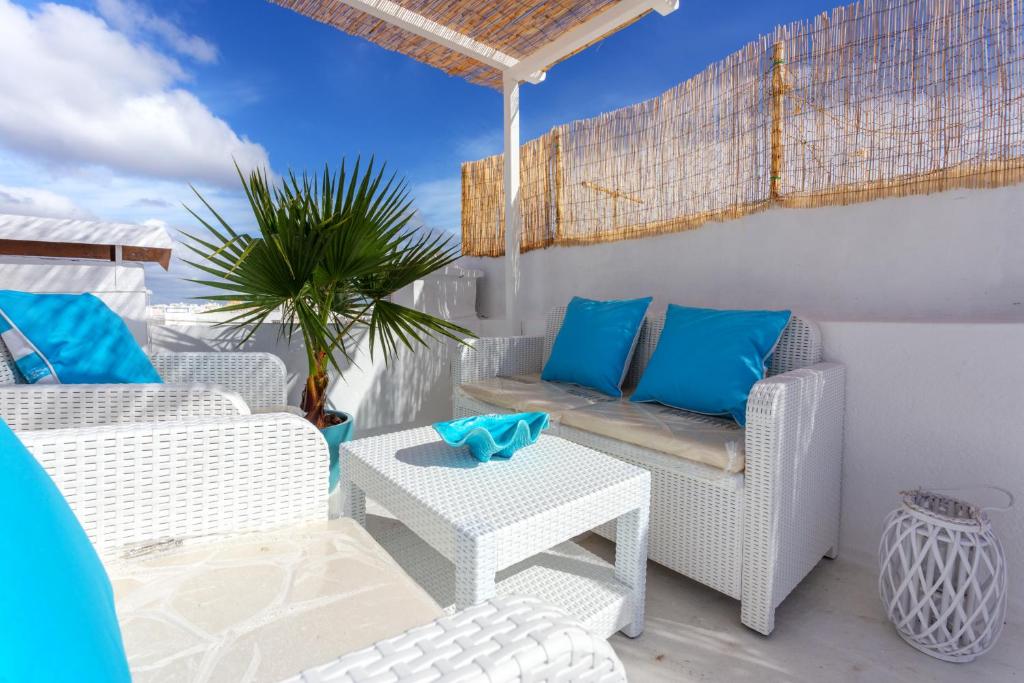 a patio with white wicker chairs and a table at CASA DO PESCADOR by Ammonite&Co in Olhão