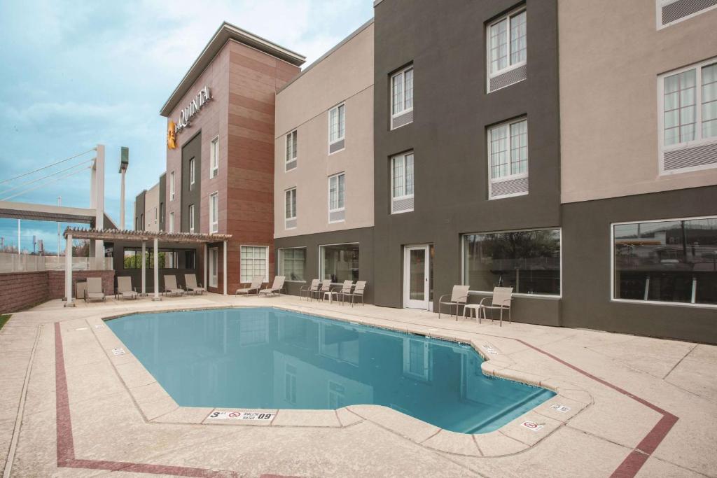 a hotel with a swimming pool in front of a building at La Quinta by Wyndham New Cumberland - Harrisburg in New Cumberland