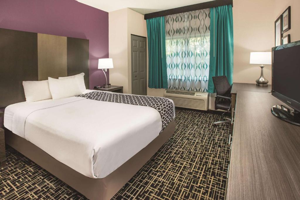 a hotel room with a large bed and a television at La Quinta Inn by Wyndham Indianapolis North at Pyramids in Indianapolis