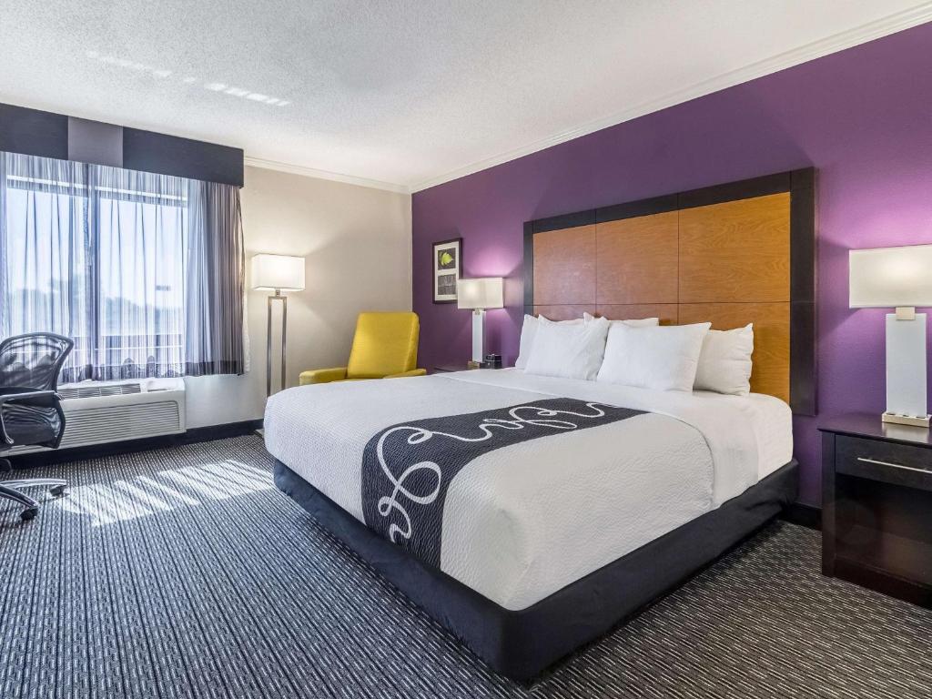 Habitación de hotel con cama grande y paredes moradas en La Quinta by Wyndham Phoenix Scottsdale en Scottsdale