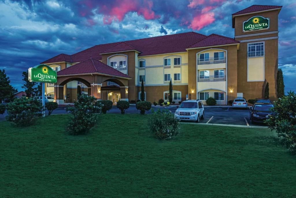 a hotel with cars parked in a parking lot at La Quinta by Wyndham Deming in Deming