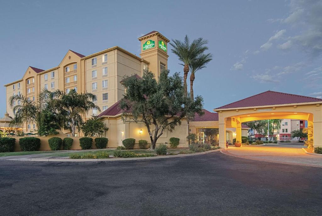 ein Hotel mit einem Gebäude mit einem Uhrturm in der Unterkunft La Quinta by Wyndham Phoenix Mesa West in Mesa