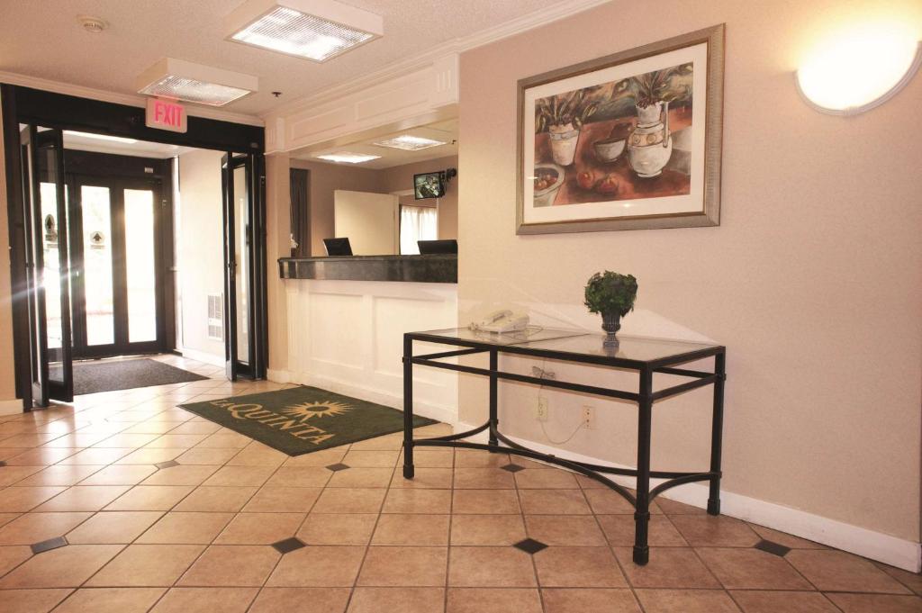 a hallway with a table and a picture on the wall at La Quinta Inn by Wyndham Detroit Canton in Canton