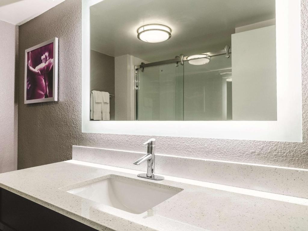 a bathroom with a sink and a large mirror at La Quinta by Wyndham Myrtle Beach - N. Kings Hwy in Myrtle Beach