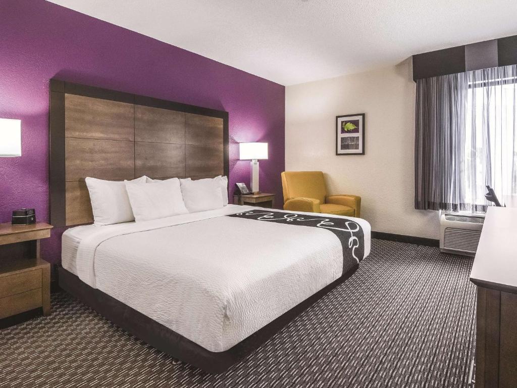 a hotel room with a large bed and a chair at La Quinta by Wyndham Myrtle Beach - N. Kings Hwy in Myrtle Beach